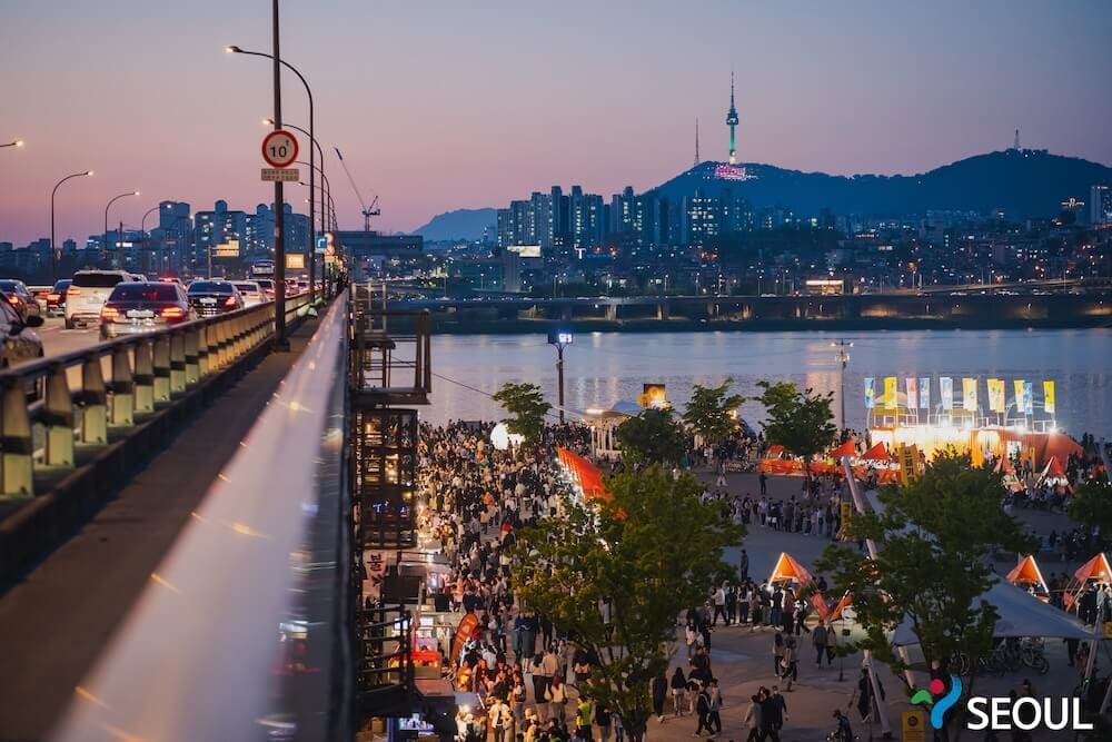 The Dazzling Banpo Bridge Rainbow Fountain | Current Schedule 2026 + How to Get There 15 Dusk view looking across the upper deck of Banpo Bridge with N Seoul Tower on the mountain ridge in the distance.