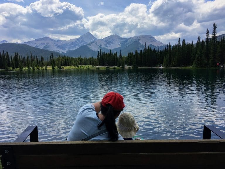 Mom and daughter looking at the forget me not pond in kananaski alberta